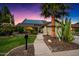 Charming home with well-manicured lawn, lush landscaping, desert plants, and modern solar panels, bathed in the warm glow of twilight at 2066 E Lockwood St, Mesa, AZ 85213