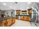 This spacious kitchen features wood cabinets, granite countertops, stainless appliances, and backyard view from the window at 2066 E Lockwood St, Mesa, AZ 85213