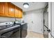Laundry room with a washer and dryer, cabinets for storage, and a door to the outside at 2066 E Lockwood St, Mesa, AZ 85213