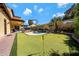 Backyard showcasing a pool, putting green, desert landscaping, and covered patio at 20791 W Main St, Buckeye, AZ 85396