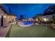 Backyard with pool, spa, putting green, covered patio, and lush landscaping at 20791 W Main St, Buckeye, AZ 85396