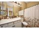 Well-lit bathroom with a white vanity, floral shower curtain, with neutral walls and tiled floors at 20791 W Main St, Buckeye, AZ 85396
