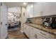 View of butler's pantry and dining room featuring white cabinetry, granite counters, and tile floors at 20791 W Main St, Buckeye, AZ 85396