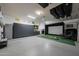 View of organized garage with storage cabinets, golf simulator, and epoxy flooring at 20791 W Main St, Buckeye, AZ 85396