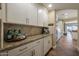 Wet bar with granite countertops and tile backsplash adjacent to the kitchen and living area at 20791 W Main St, Buckeye, AZ 85396