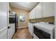 Functional laundry room featuring modern washer, dryer, cabinets, and utility sink at 20791 W Main St, Buckeye, AZ 85396