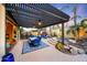 Covered patio area with a dining table, fireplace, and spa, perfect for outdoor entertaining at 20791 W Main St, Buckeye, AZ 85396