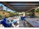 An elegant covered patio features an outdoor bar, dining area, and comfortable seating overlooking the lush backyard at 20791 W Main St, Buckeye, AZ 85396