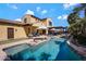 This home features a stunning backyard pool, rock waterfall, outdoor lounge area, and meticulous landscaping at 20791 W Main St, Buckeye, AZ 85396