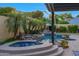 Relax in style with this luxurious pool and spa featuring a rock waterfall and lush tropical landscaping at 20791 W Main St, Buckeye, AZ 85396