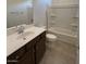 Bathroom featuring a single vanity, large mirror, and shower over tub with grab bars at 25348 W Bowker St, Buckeye, AZ 85326