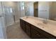 Bathroom featuring a dual sink vanity, large mirror, and glass-enclosed shower at 25348 W Bowker St, Buckeye, AZ 85326