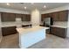 Spacious kitchen featuring a large island, stainless steel refrigerator, and dark wood cabinetry at 25348 W Bowker St, Buckeye, AZ 85326