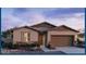 Charming single-story home featuring stone accents, a two-car garage, and a welcoming front entrance at 25354 W Bowker St, Buckeye, AZ 85326