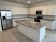 Modern kitchen featuring white cabinets, stainless steel appliances, and a granite island at 25354 W Bowker St, Buckeye, AZ 85326