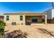 Wide backyard with gravel, an outdoor kitchen area, and the home's stucco facade with covered patio at 28259 N Chalcocite St, San Tan Valley, AZ 85143
