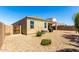 Wide backyard with gravel, an outdoor kitchen area, and the home's stucco facade with covered patio at 28259 N Chalcocite St, San Tan Valley, AZ 85143