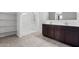 Bright bathroom features a shower, dark cabinets, tile floors and a double sink vanity at 28259 N Chalcocite St, San Tan Valley, AZ 85143
