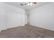 Bedroom features neutral carpet, a ceiling fan, and white closet doors at 28259 N Chalcocite St, San Tan Valley, AZ 85143