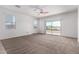 Bright bedroom with carpet flooring, ceiling fan, large window, and sliding glass door at 28259 N Chalcocite St, San Tan Valley, AZ 85143