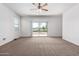 Bright bedroom with carpet flooring, ceiling fan, large window, and sliding glass door at 28259 N Chalcocite St, San Tan Valley, AZ 85143