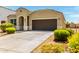 Inviting single-story home featuring a well-maintained yard, a dark front door and attached garage at 28259 N Chalcocite St, San Tan Valley, AZ 85143