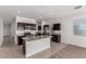 Kitchen boasts stainless steel appliances, granite counters, dark cabinetry and a center island with a sink at 28259 N Chalcocite St, San Tan Valley, AZ 85143