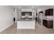 Bright kitchen features stainless appliances, granite counters, dark cabinetry and an island with sink at 28259 N Chalcocite St, San Tan Valley, AZ 85143
