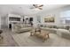 Open-concept living room featuring a large sectional sofa, adjacent to a modern kitchen with stainless steel appliances at 28259 N Chalcocite St, San Tan Valley, AZ 85143