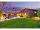 Expansive backyard featuring a well-manicured lawn, outdoor seating, lush desert landscaping, and an inviting outdoor pool at 3425 N 50Th Pl, Phoenix, AZ 85018