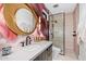 Modern bathroom featuring sleek vanity, round mirror and glass-enclosed shower at 3425 N 50Th Pl, Phoenix, AZ 85018