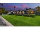 Expansive home exterior with a lush green lawn, mature landscaping, and a gated entrance at 3425 N 50Th Pl, Phoenix, AZ 85018