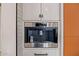 Built-in stainless steel Wolf coffee maker with custom white cabinets and chrome pitcher for convenience at 3425 N 50Th Pl, Phoenix, AZ 85018