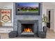 Inviting living room featuring a gray stone fireplace with a TV displaying the home's exterior at 3425 N 50Th Pl, Phoenix, AZ 85018