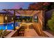 Outdoor entertainment area with a covered bar, outdoor television, and a view of the inviting pool and landscape at 3425 N 50Th Pl, Phoenix, AZ 85018