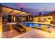 Luxurious outdoor area featuring a sparkling pool with built in bar, inviting lounge spaces, and custom landscape lighting at 3425 N 50Th Pl, Phoenix, AZ 85018