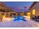 Inviting backyard oasis featuring a sparkling pool, spa, covered pergola with outdoor television, and a charming fire pit area at 3425 N 50Th Pl, Phoenix, AZ 85018