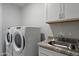 Functional laundry room with a washer, dryer, sink, and storage cabinets at 3855 S Mcqueen Rd # 101, Chandler, AZ 85286
