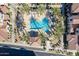 Aerial view of a community pool with ample seating, palm trees, and covered areas for shade at 3855 S Mcqueen Rd # 101, Chandler, AZ 85286