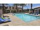 Community pool with various colored lounge chairs and shaded gazebo area with townhomes in the background at 3855 S Mcqueen Rd # 101, Chandler, AZ 85286