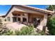 Well-maintained covered patio with outdoor seating and views of lush desert landscaping, enhancing the home's outdoor appeal at 3928 N 151St Ave, Goodyear, AZ 85395