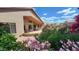 Relaxing covered back patio with comfortable seating surrounded by colorful flowers and lush, well-maintained landscaping at 3928 N 151St Ave, Goodyear, AZ 85395