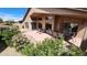 Tranquil covered patio with outdoor seating and views of the surrounding manicured desert landscaping and flowering bushes at 3928 N 151St Ave, Goodyear, AZ 85395