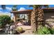 Welcoming outdoor space with a covered patio, dining set, and lush desert landscaping, including cactus and blooming flowers at 3928 N 151St Ave, Goodyear, AZ 85395