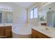 Well-lit bathroom with double vanities, a soaking tub, and a window for natural light at 3928 N 151St Ave, Goodyear, AZ 85395
