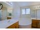 Well-lit bathroom with double vanities, a soaking tub, and a window for natural light at 3928 N 151St Ave, Goodyear, AZ 85395