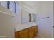Bright bathroom featuring wood cabinets, a long mirror, and a window for natural lighting at 3928 N 151St Ave, Goodyear, AZ 85395