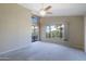 Bright bedroom with neutral walls, large window, ceiling fan, and sliding glass door to the backyard patio at 3928 N 151St Ave, Goodyear, AZ 85395