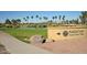 PebbleCreek Model Home Village sign next to green space and a lake at 3928 N 151St Ave, Goodyear, AZ 85395