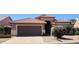 Charming single-story home featuring a terracotta roof, brown garage door, and desert landscaping at 3928 N 151St Ave, Goodyear, AZ 85395